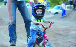 Parent assisting a young child on a strider bike